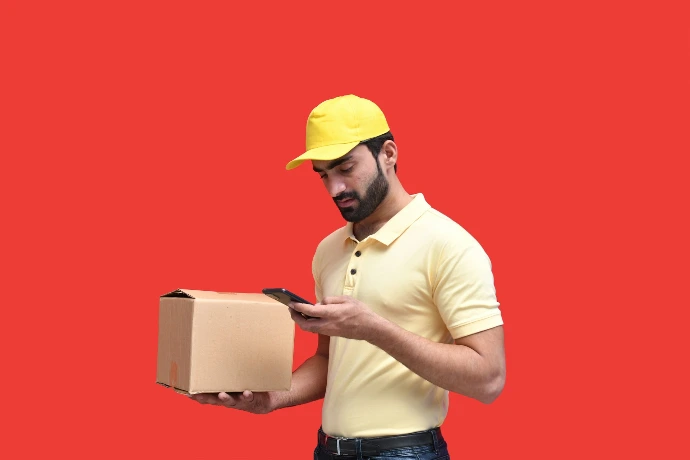 a man in a yellow hat looking at a phone
